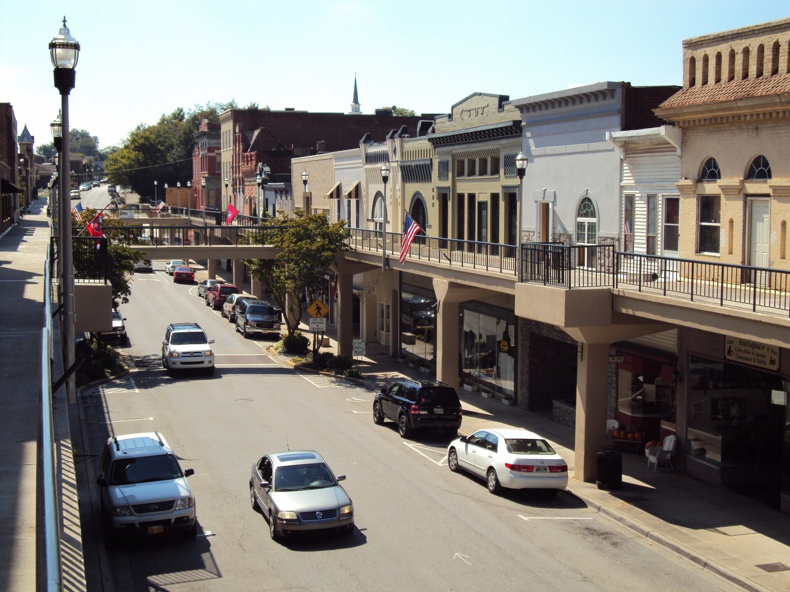 Downtown Morristown, Tennessee: brick shopfronts under its raised overhead sidewalk, cars parked along Main Street